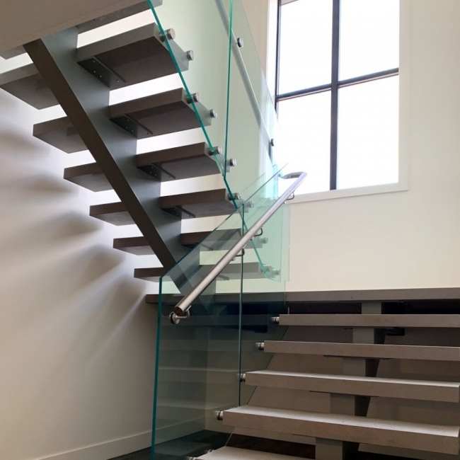 Custom Staircase With Glass Panels And Metal Rails