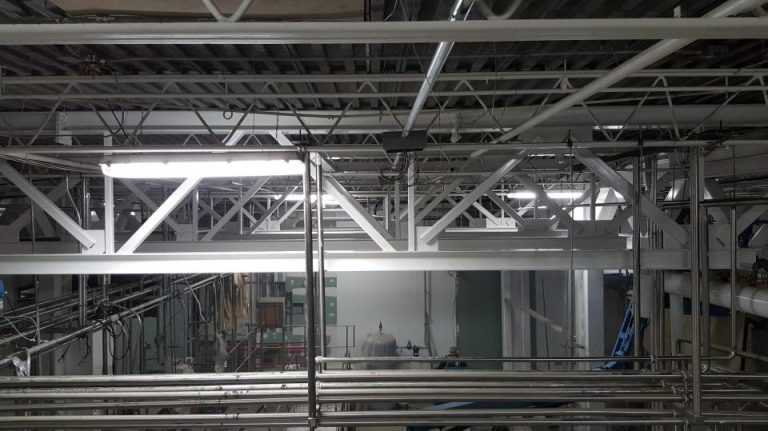 Steel bracing reinforcing an existing commercial structure alongside building services